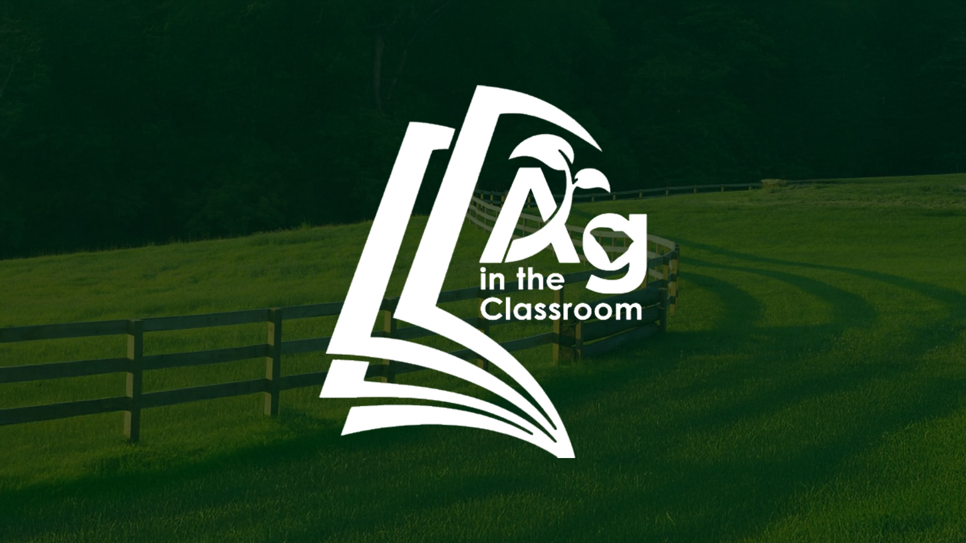 Logo for "Ag in the Classroom" featuring a stylized book and plant design against a green field and wooden fence background.